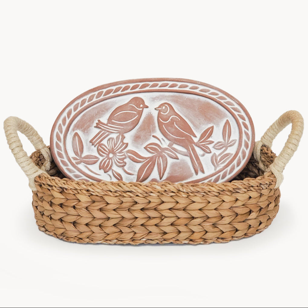 Decorative plate with bird design in a woven basket on a white background