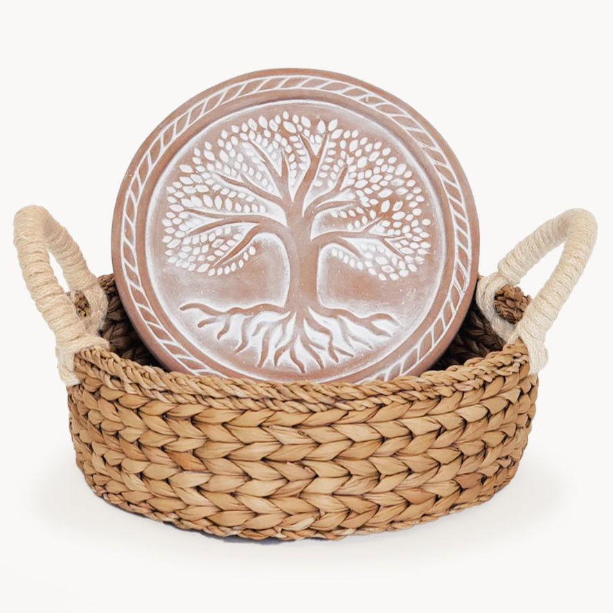 Decorative plate with tree design in a woven basket on a white background