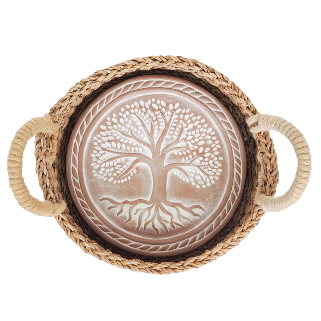 Decorative bowl with tree of life design and braided handles on a white background